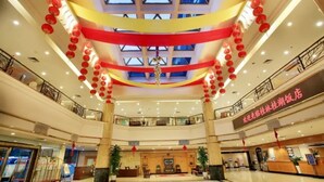 A multi-level hotel lobby with a central atrium, red lanterns, and a reception desk. - Guilin Park Hotel (Guilin)
