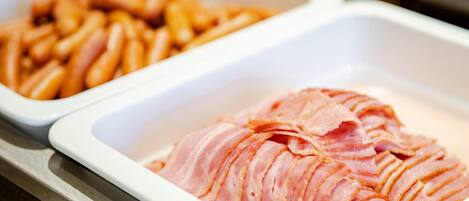 Two white trays, one with sliced ham and the other with French fries.
