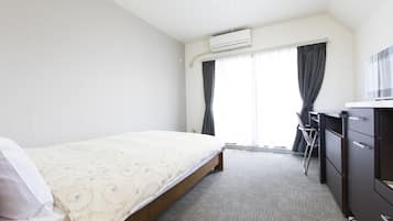 Una habitación de hotel con cama, escritorio y armario.