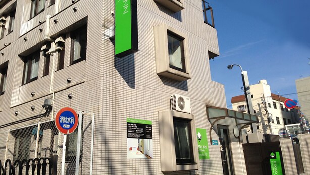 Un bâtiment avec une enseigne indiquant « FlexStay Inn » et un panneau « Stationnement interdit ».