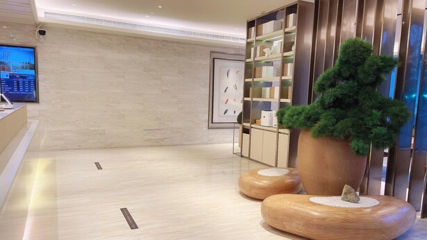 A modern lobby with a reception desk, a large potted plant, and a bookshelf. - Ji Hotel (Shanghai)