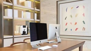 A modern workspace with a desktop computer, a coffee machine, and a framed artwork on the wall. - Ji Hotel (Shanghai)