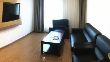Una sala de estar moderna con un televisor de pantalla plana montado en la pared, un sofá y una mesa de centro.