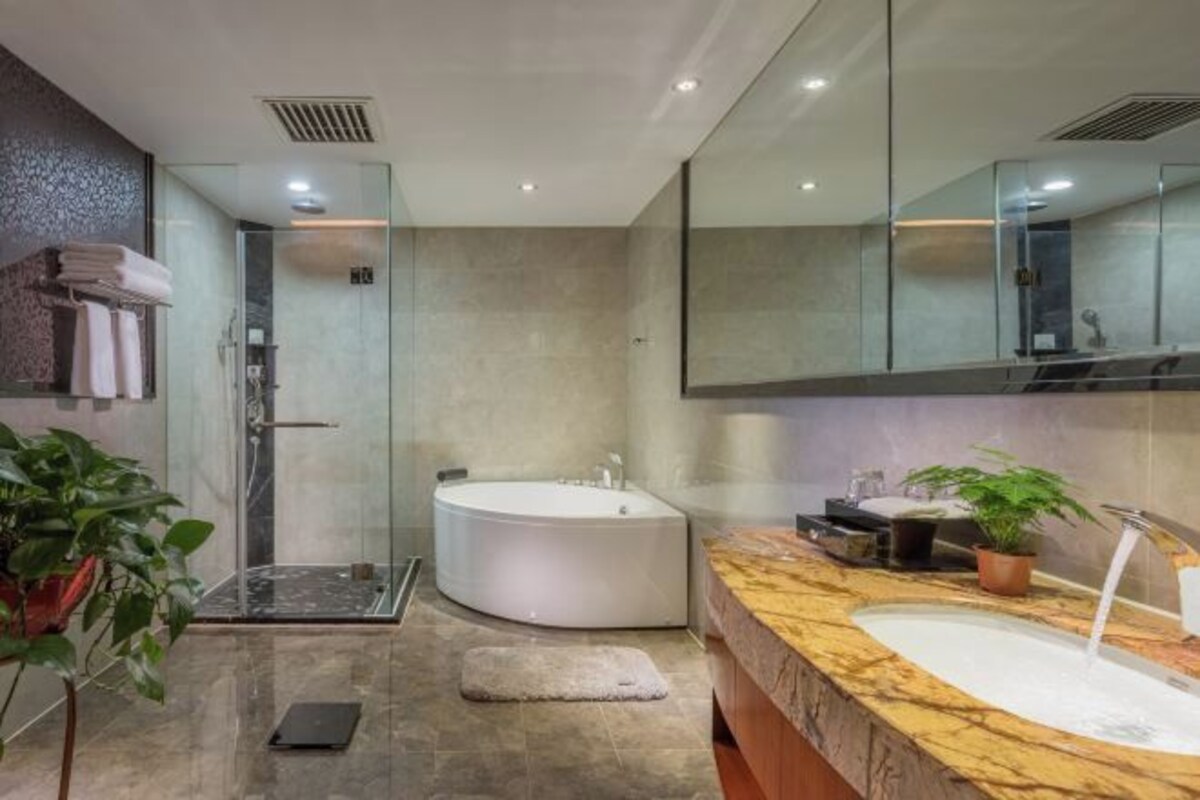 A modern bathroom with a large bathtub, a walk-in shower, and a marble vanity.