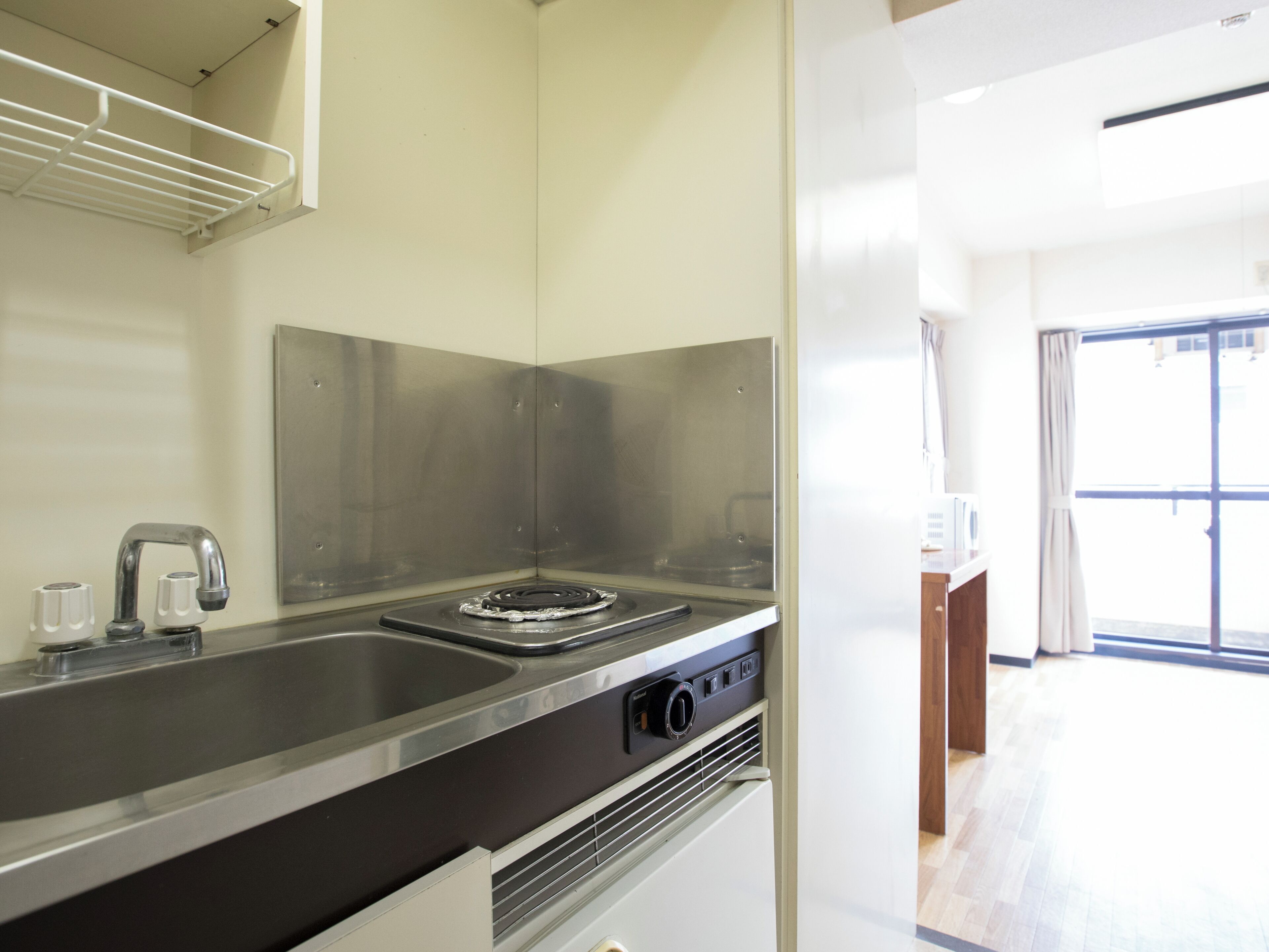 Una cocina moderna con electrodomésticos de acero inoxidable, horno empotrado y pileta.
