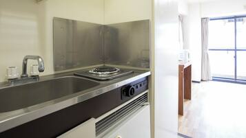 Una cocina moderna con electrodomésticos de acero inoxidable, horno empotrado y pileta.