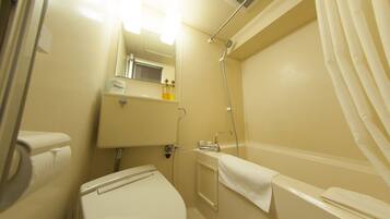 A small, clean bathroom with a toilet, sink, and shower.
