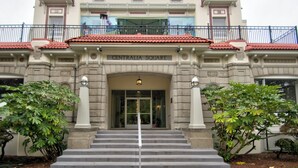 Un edificio con un cartel que dice "CENTRALIA SQUARE" en la entrada, con una escalera monumental y un balcón con barandilla.
