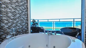 A bathroom with a large bathtub, a glass shower, and a view of the ocean. - Sokcho Esher House Pension (Sokcho)