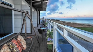 A balcony with a view of the beach, a table with chairs, and a swing. - Sokcho Esher House Pension (Sokcho)