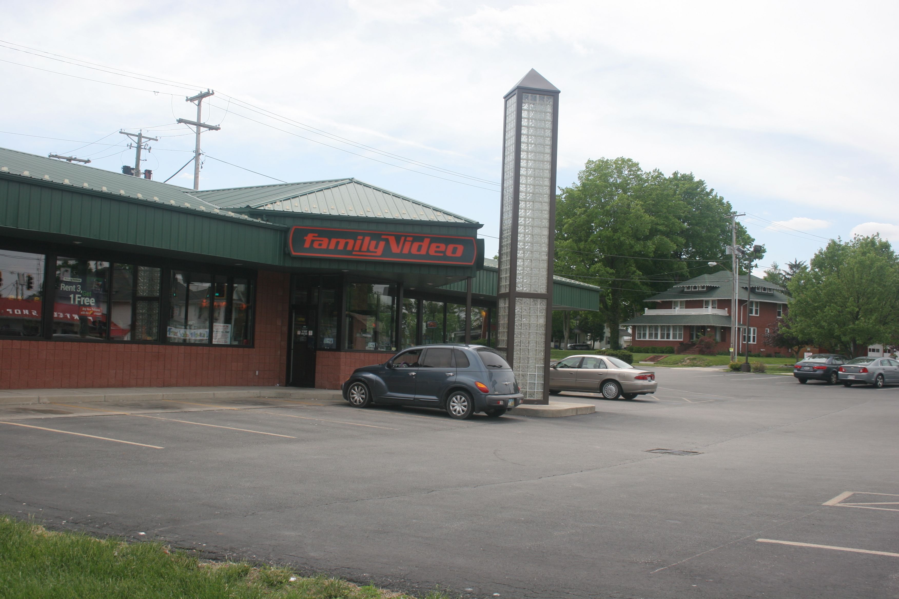 A Family Video store with a parking lot and a tall monument in front.