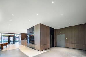 A modern interior with a reception desk, a seating area, and a large glass partition. - Boinn Zhi Xuan Hotel（Nantong Tongzhou Coach Station Jianshe Lu ） (Nantong)