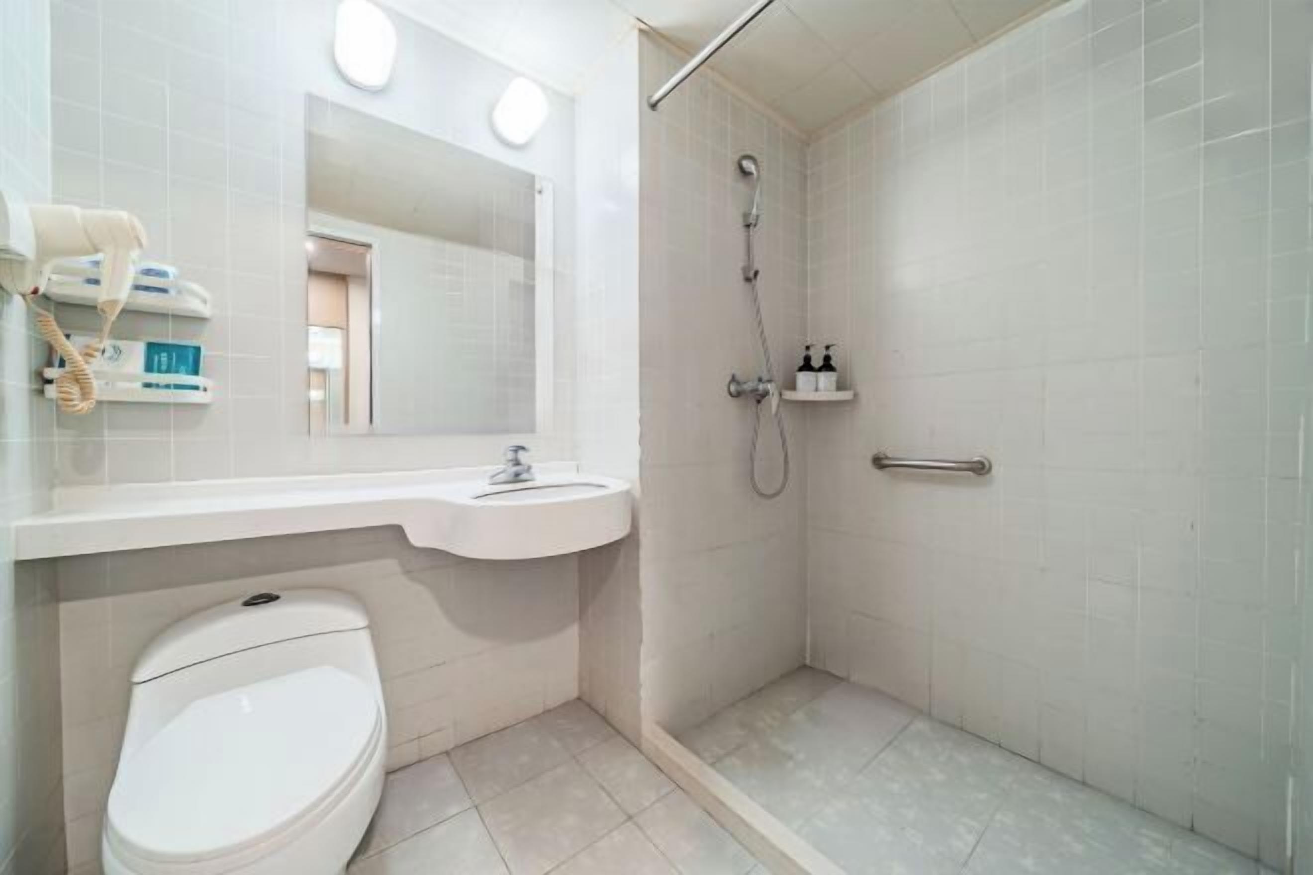 A modern bathroom with a toilet, sink, and shower.