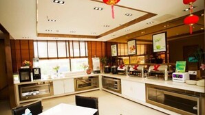 A modern hotel room with a dining area, a kitchen, and a view of the city. - Boinn Zhi Xuan Hotel（Nantong Tongzhou Coach Station Jianshe Lu ） (Nantong)