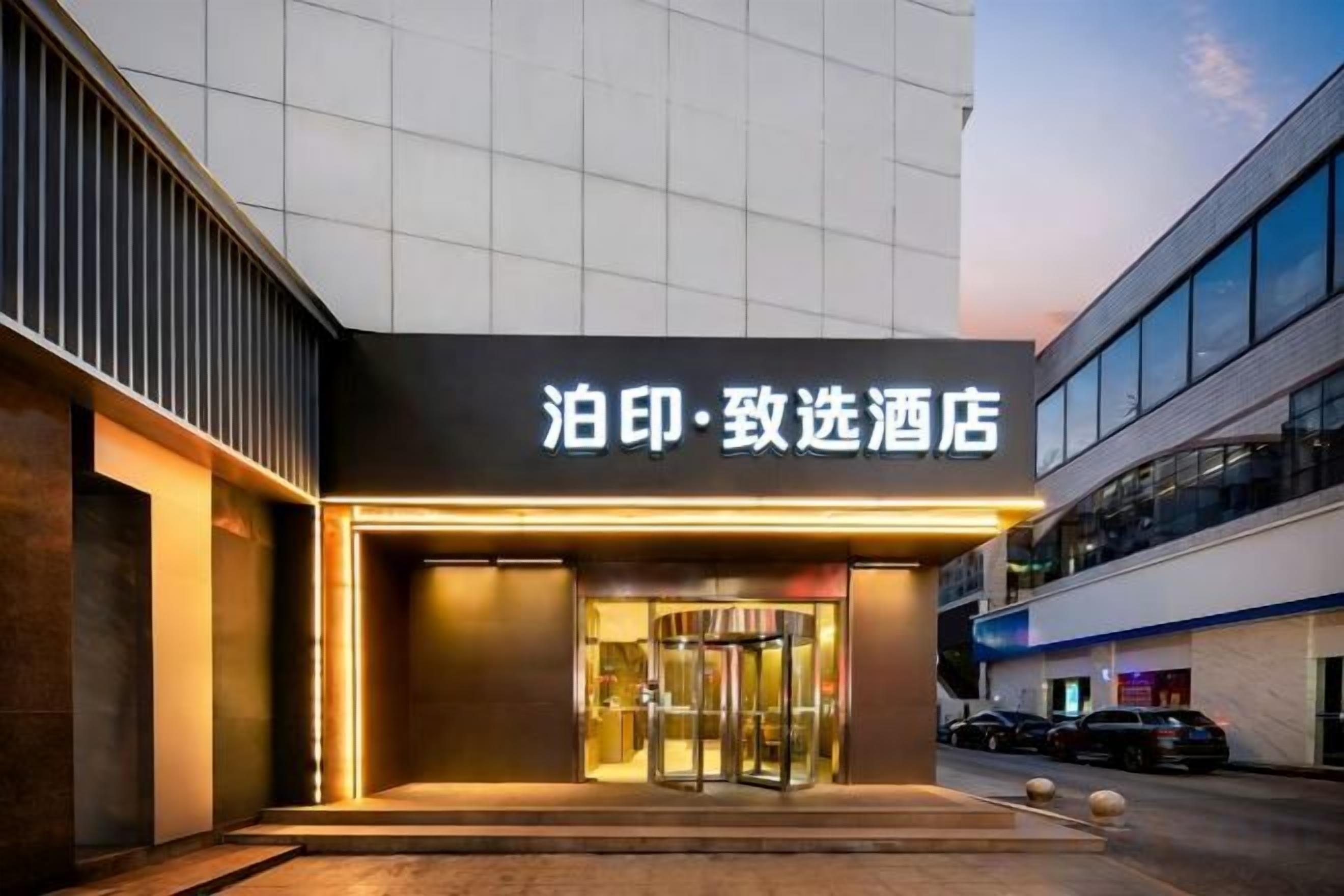 A hotel entrance with a revolving door and a sign above it.