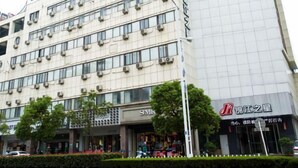 A multi-story building with signage for JINJIANG INN and a Safaricom store. - Boinn Zhi Xuan Hotel（Nantong Tongzhou Coach Station Jianshe Lu ） (Nantong)