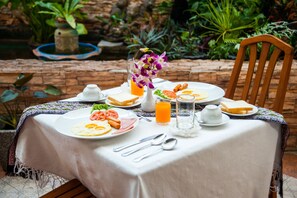 Enjoy a leisurely breakfast amidst lush greenery and a serene garden setting.