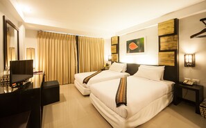 Comfortable room with two single beds, desk, and wall-mounted telephone.