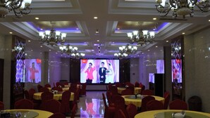 A banquet hall with round tables covered in yellow tablecloths, red chairs, and chandeliers. - GreenTree Inn TaiYuan Jiancaoping District XingHua Street Hotel (Taiyuan)