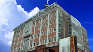 A multi-story building with a prominent red brick facade, multiple windows, and a large sign on the side. - GreenTree Inn TaiYuan Jiancaoping District XingHua Street Hotel (Taiyuan)