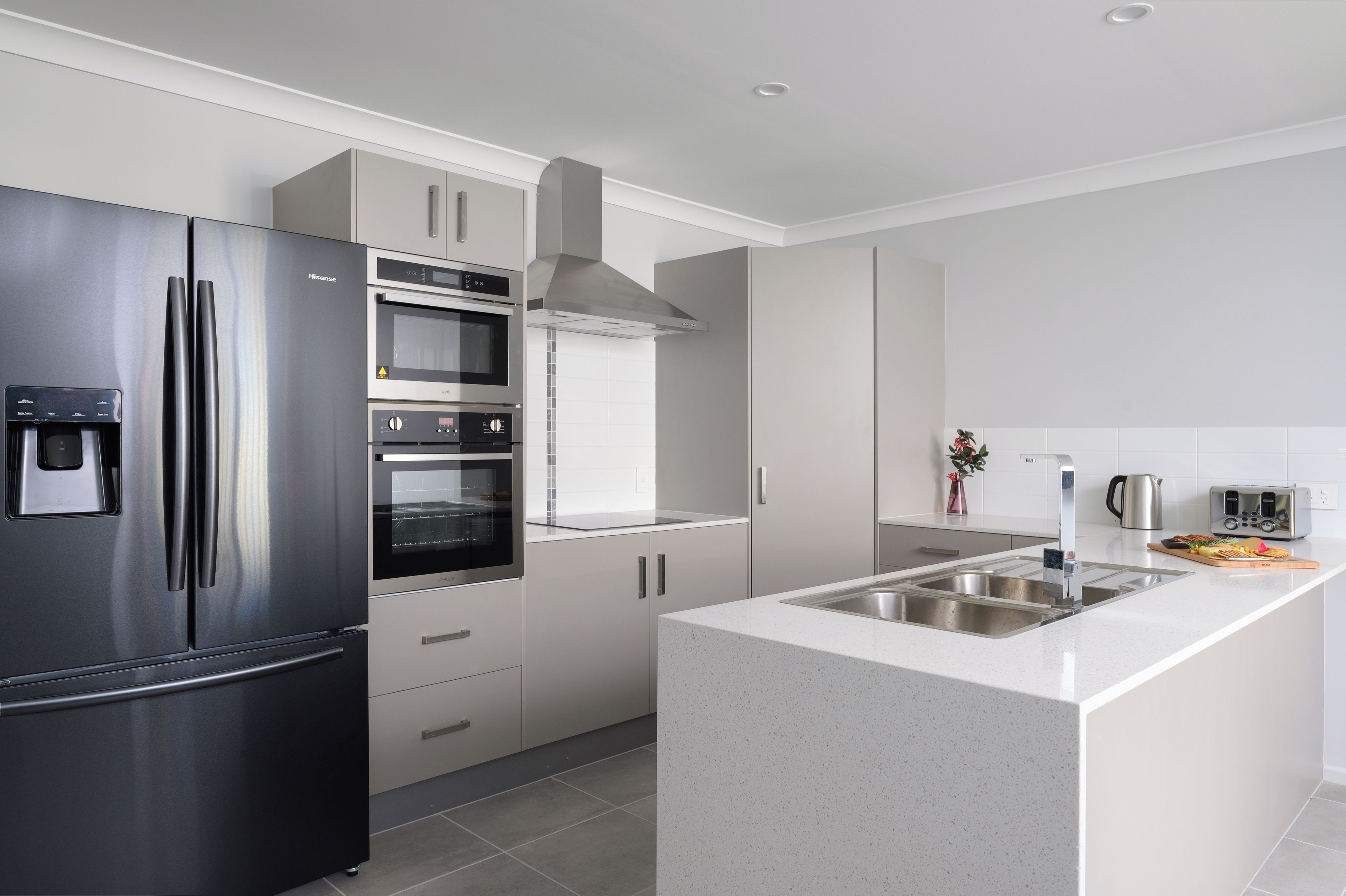 A modern kitchen with stainless steel appliances, a built-in oven, and a granite countertop.