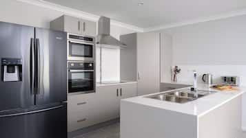 Una cocina moderna con electrodomésticos de acero inoxidable, horno empotrado y encimera de granito.