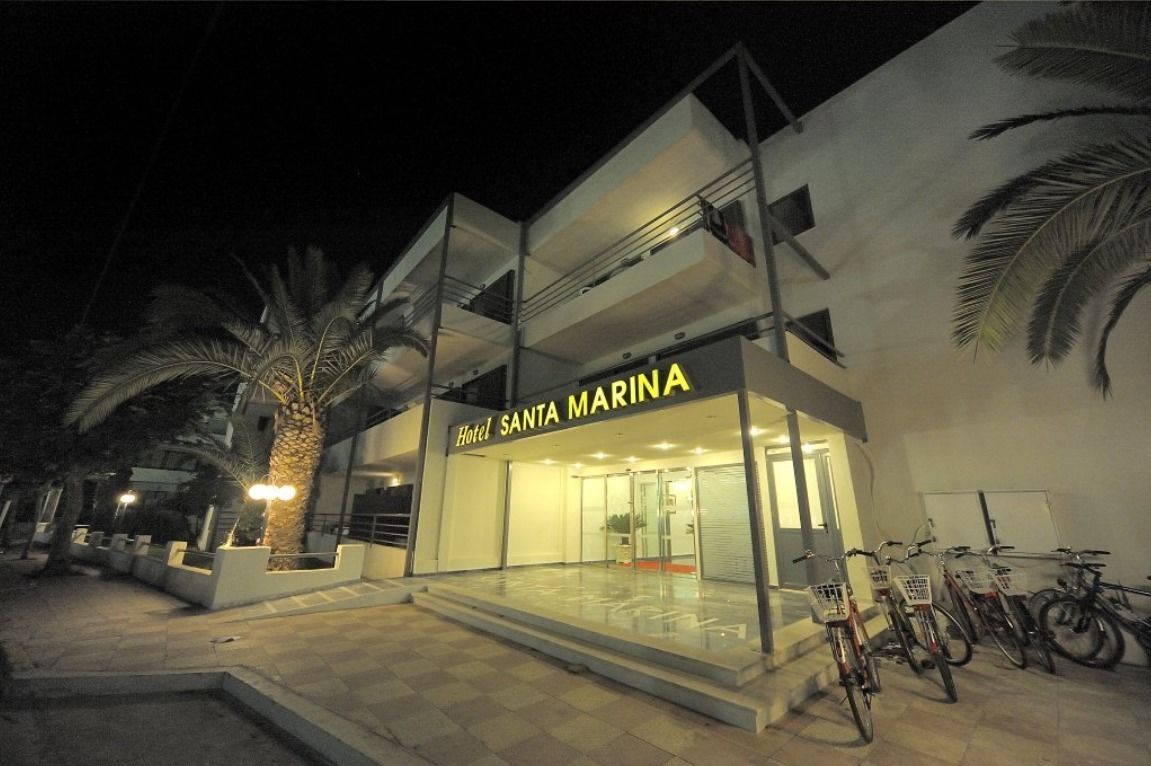A hotel named 'Hotel Santa Marina' with a modern facade, glass entrance, and a bicycle parking area.