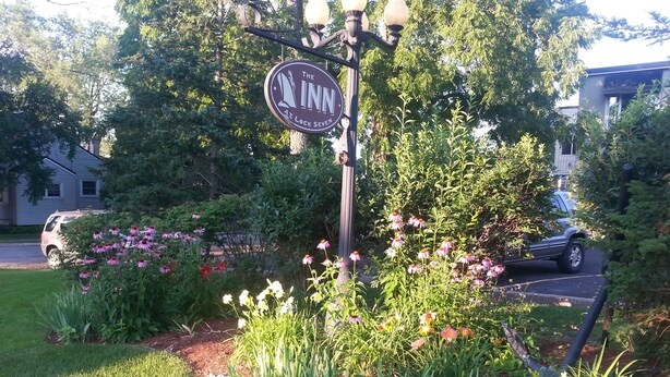 A sign for 'The Inn at Lock Seven' with a garden featuring various plants and flowers.