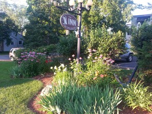 A sign for 'The Inn at Lock Seven' with a garden featuring various plants and flowers.