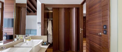 A modern bathroom with two sinks, a mirror, and wooden paneling.