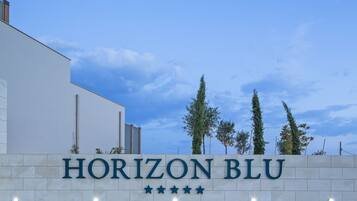 A sign for "HORIZON BLU" with a clear sky and trees in the background.