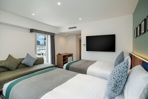 A hotel room with two beds, a sofa, a TV, and a window with a view of buildings. - Hotel MyStays Fukuoka Tenjin Minami (Fukuoka)