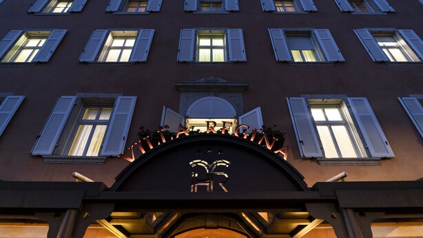 A building facade with multiple windows and a central entrance with a sign. - Hotel Villa Regina (Levico Terme)