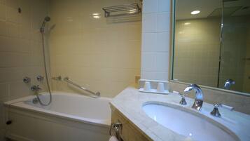 A bathroom with a bathtub, a sink, and a mirror.