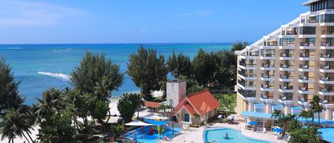 A resort with a large pool, a beach, and ocean views.