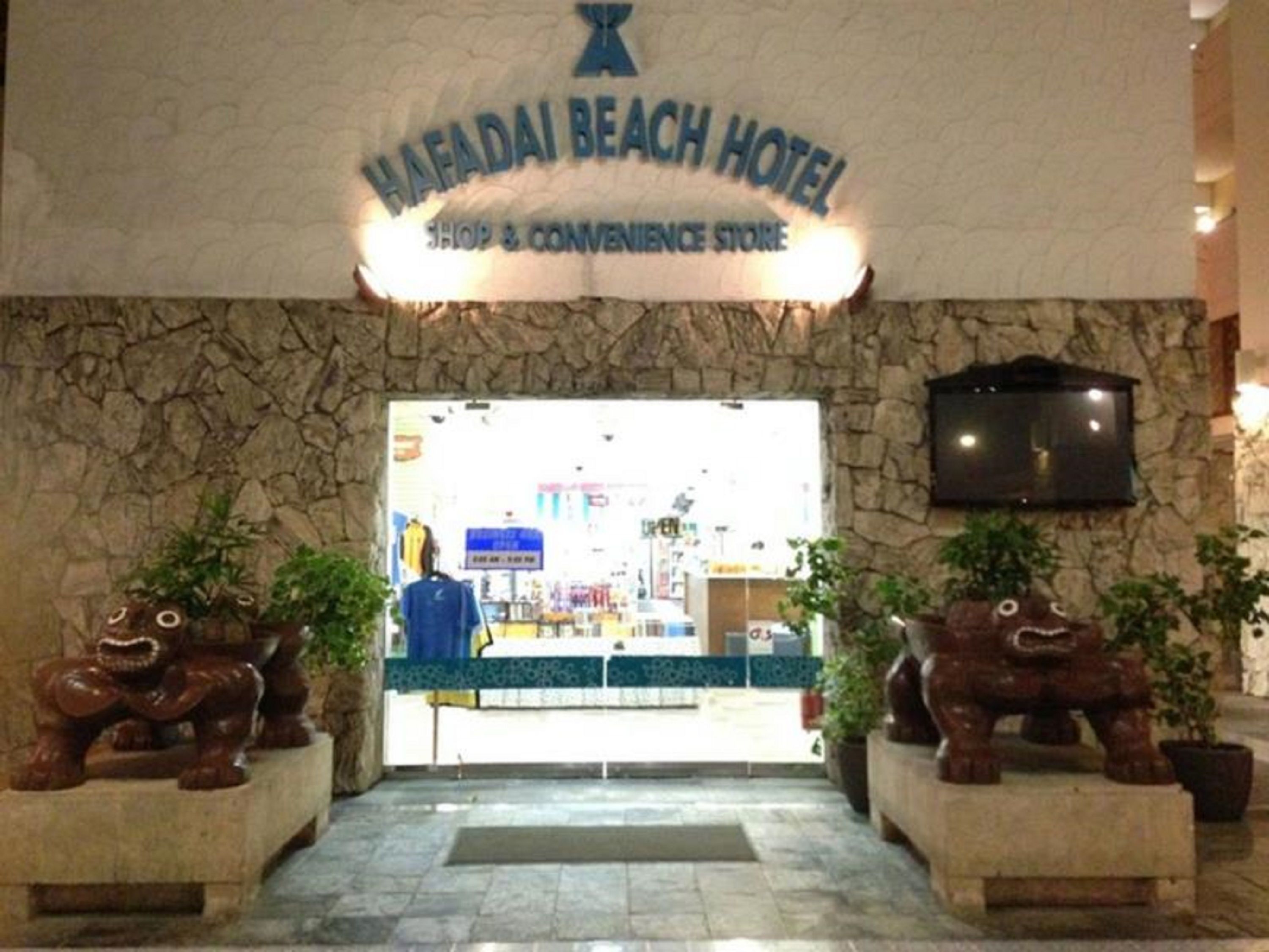 De ingang van Hotel Hafadai Beach, met een winkel en gemakswinkel.