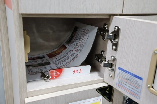 A wooden cabinet with a metal latch, a white label with the number 302, and a blue informational sign.