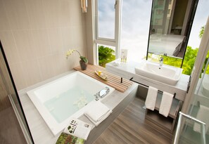 A modern bathroom with a large bathtub, two sinks, a wooden shelf with toiletries, and a view of greenery outside. - Teascape Chiayi (Chiayi City)