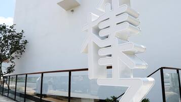 Un bâtiment moderne avec une grande sculpture blanche devant.
