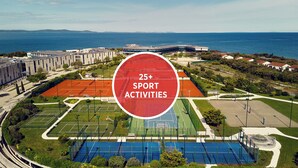 Vista aérea de un complejo deportivo con varias canchas de tenis, una cancha de baloncesto y una piscina.