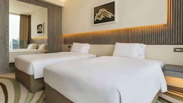 A hotel room with two beds, a large mirror, and a city view.