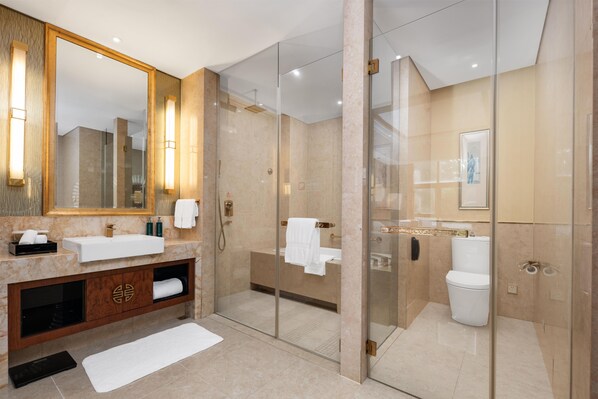 A modern bathroom with a large mirror, a vanity with a sink, and a glass-enclosed shower area.
