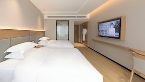 A hotel room with two beds, a television mounted on the wall, and a door leading to a bathroom. - Baigang International Hotel (Chengdu)