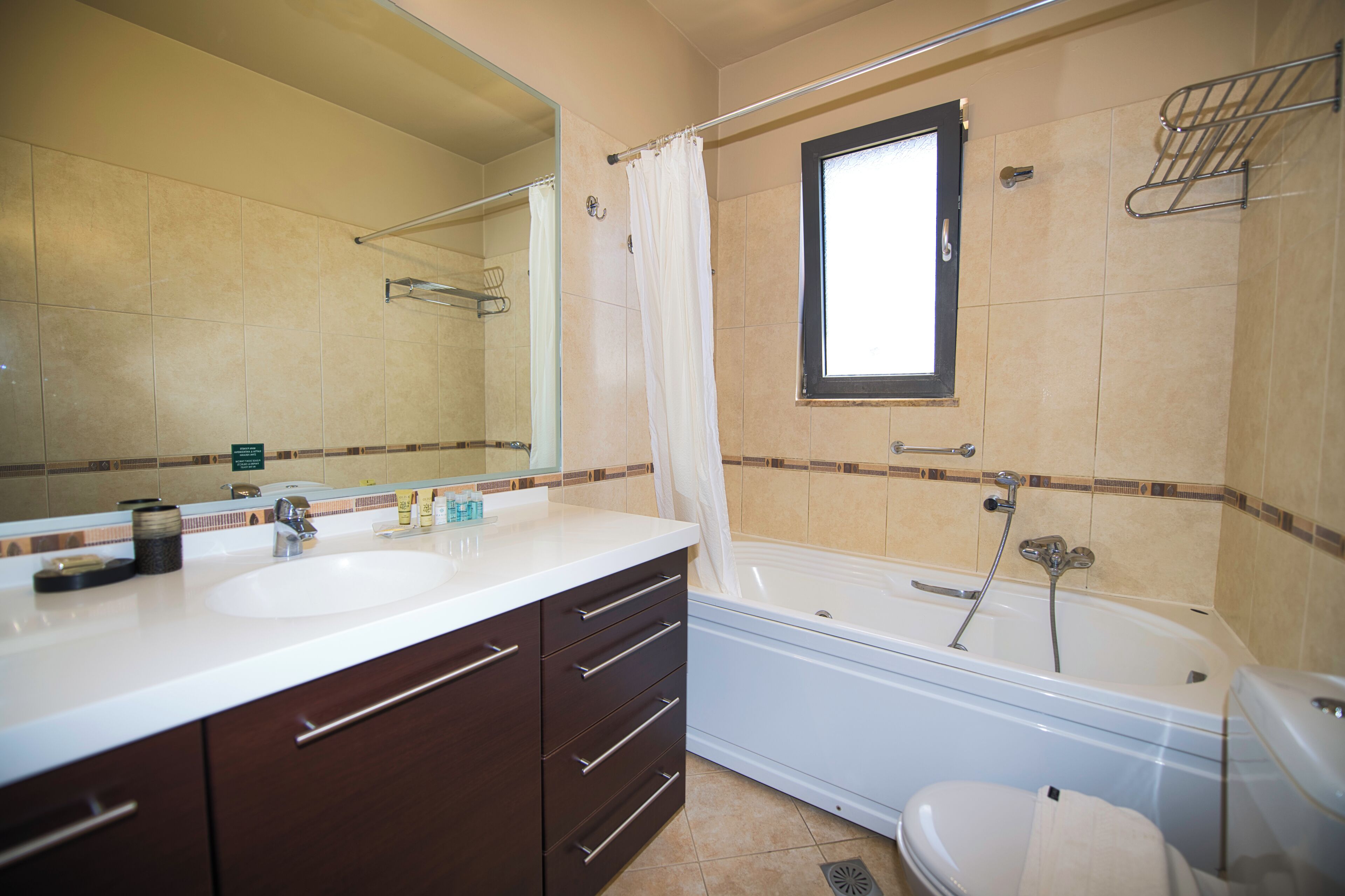 A bathroom with a double sink vanity, a bathtub, and a toilet.