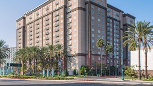 A multi-story hotel with balconies, palm trees, and a landscaped area in front. - WorldMark Anaheim (Anaheim)