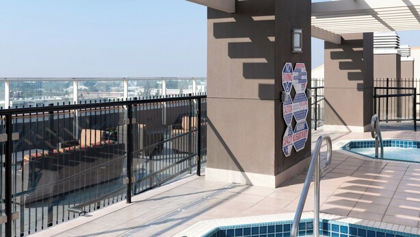 A rooftop pool area with a hot tub, a glass railing, and a view of the cityscape. - WorldMark Anaheim (Anaheim)