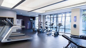 A modern gym with treadmills, elliptical machines, and a bench. - WorldMark Anaheim (Anaheim)