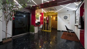 Un intérieur moderne avec un sol en marbre noir, des touches de rouge et une porte en bois.