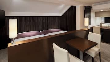 Una habitación de hotel moderna con una cama, un escritorio y una zona de comedor.