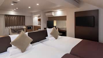 Habitación de hotel con dos camas, un escritorio, un televisor y un baño.